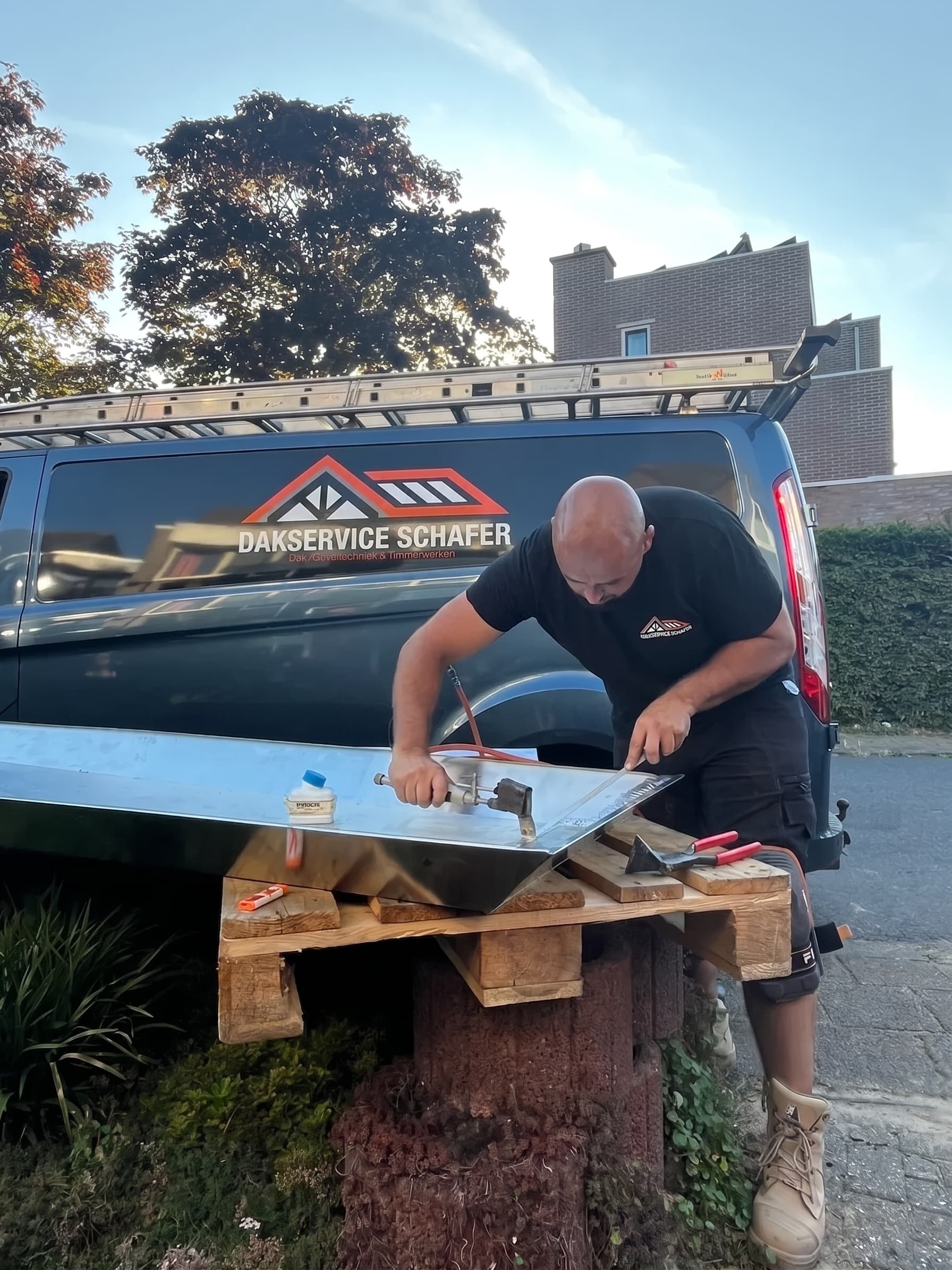 Vakman soldeert een zinken gootstuk op locatie
